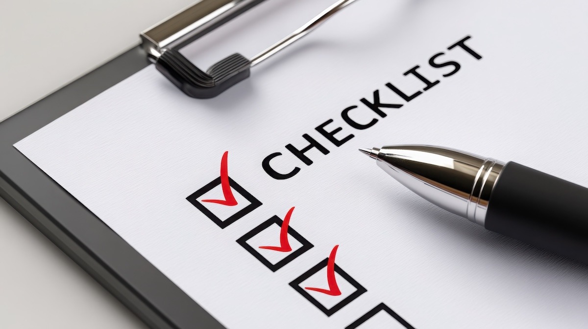 A clipboard holding a checklist with four checked boxes and a pen resting below the heading.