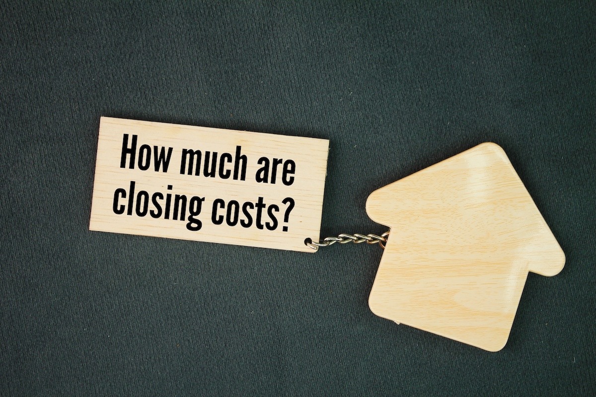 A close-up of a keychain with a house-shaped tag and another tag that reads “How much are closing costs?”.
