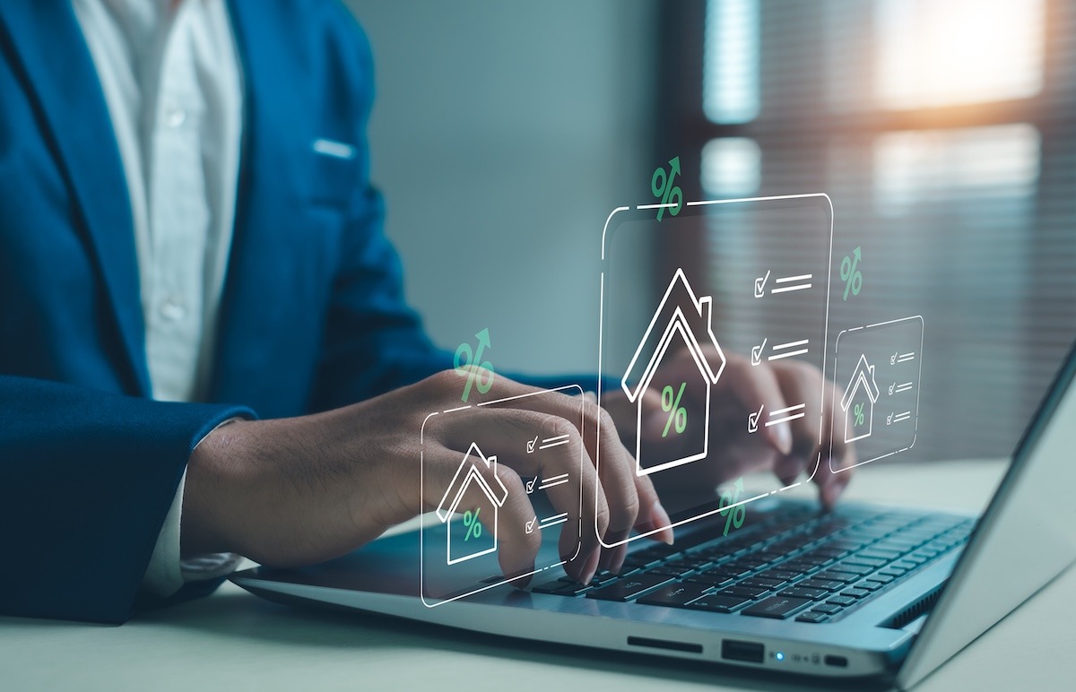 Hands on a laptop keyboard with overlaid charts and percentage graphs displayed on the screen.