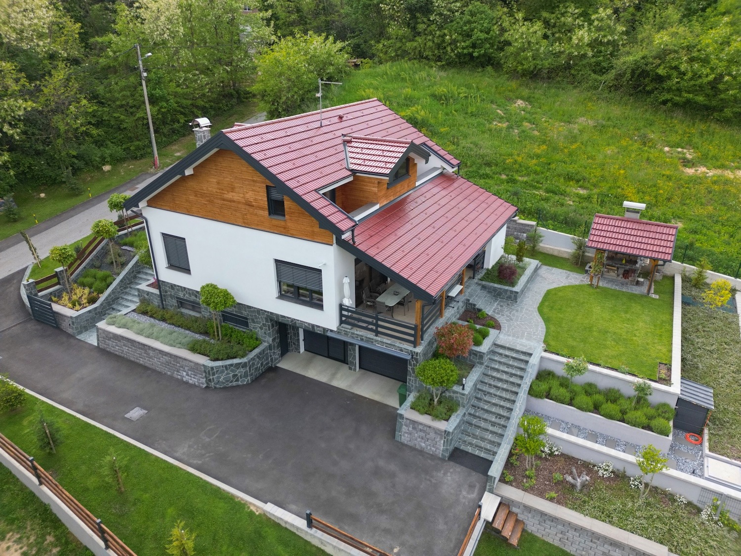 Aerial view of a residential property showing a house, fencing, outbuilding, landscaping, and other property features.