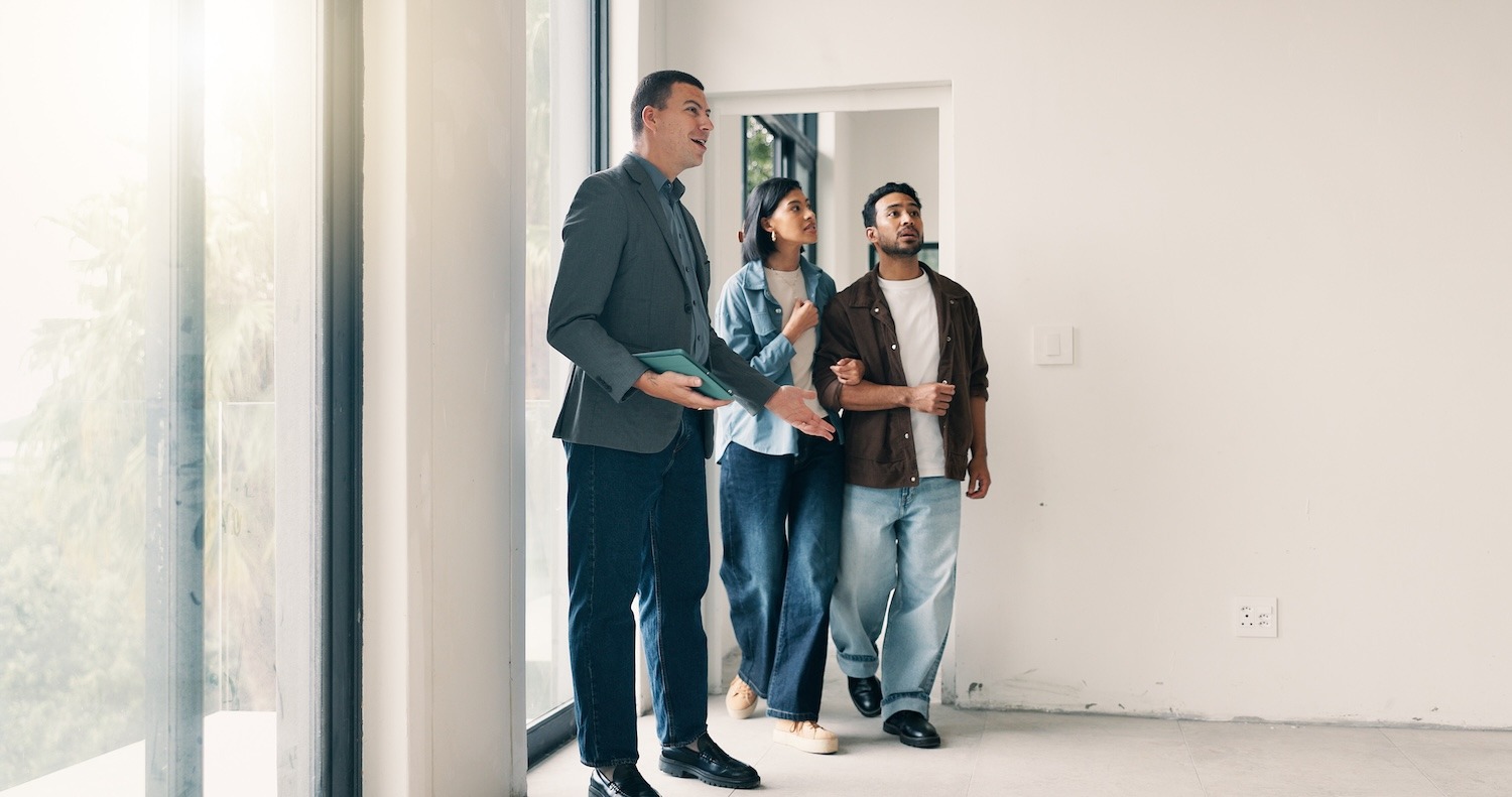 Home buyers and a real estate professional conducting a final walkthrough of an empty home.