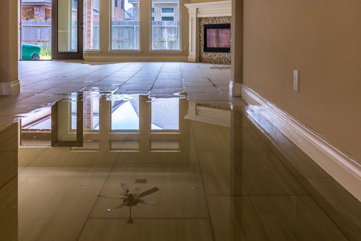 A home interior showing water damage and standing water on the floor.