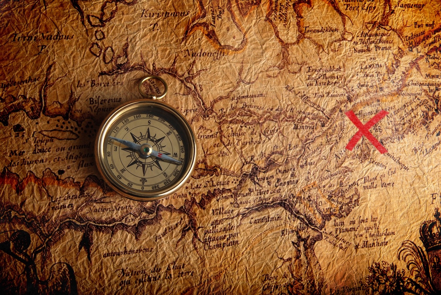Antique map with a compass and red X marking a location