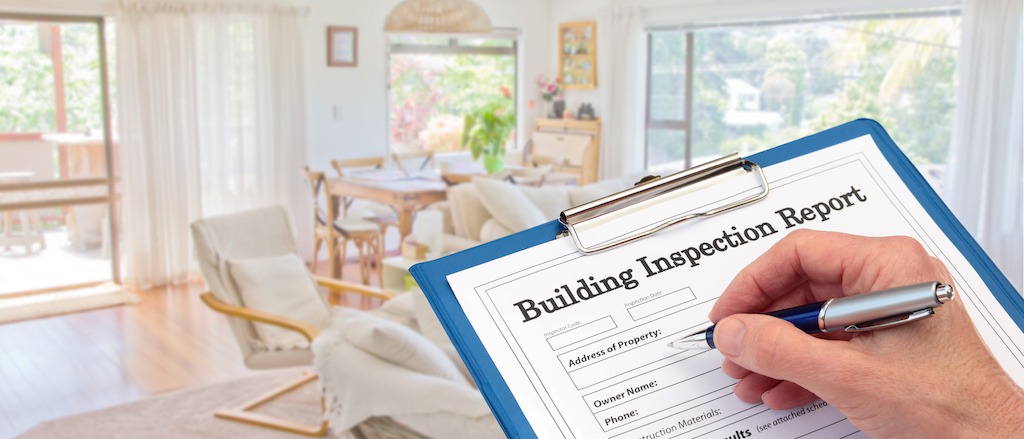 Home Inspection. Building Inspector completing an inspection form on clipboard inside living room