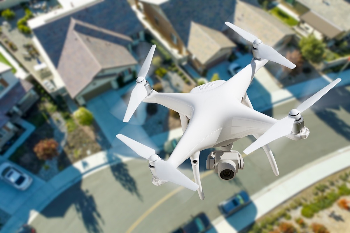 A drone hovering above a residential neighbourhood viewed from above.