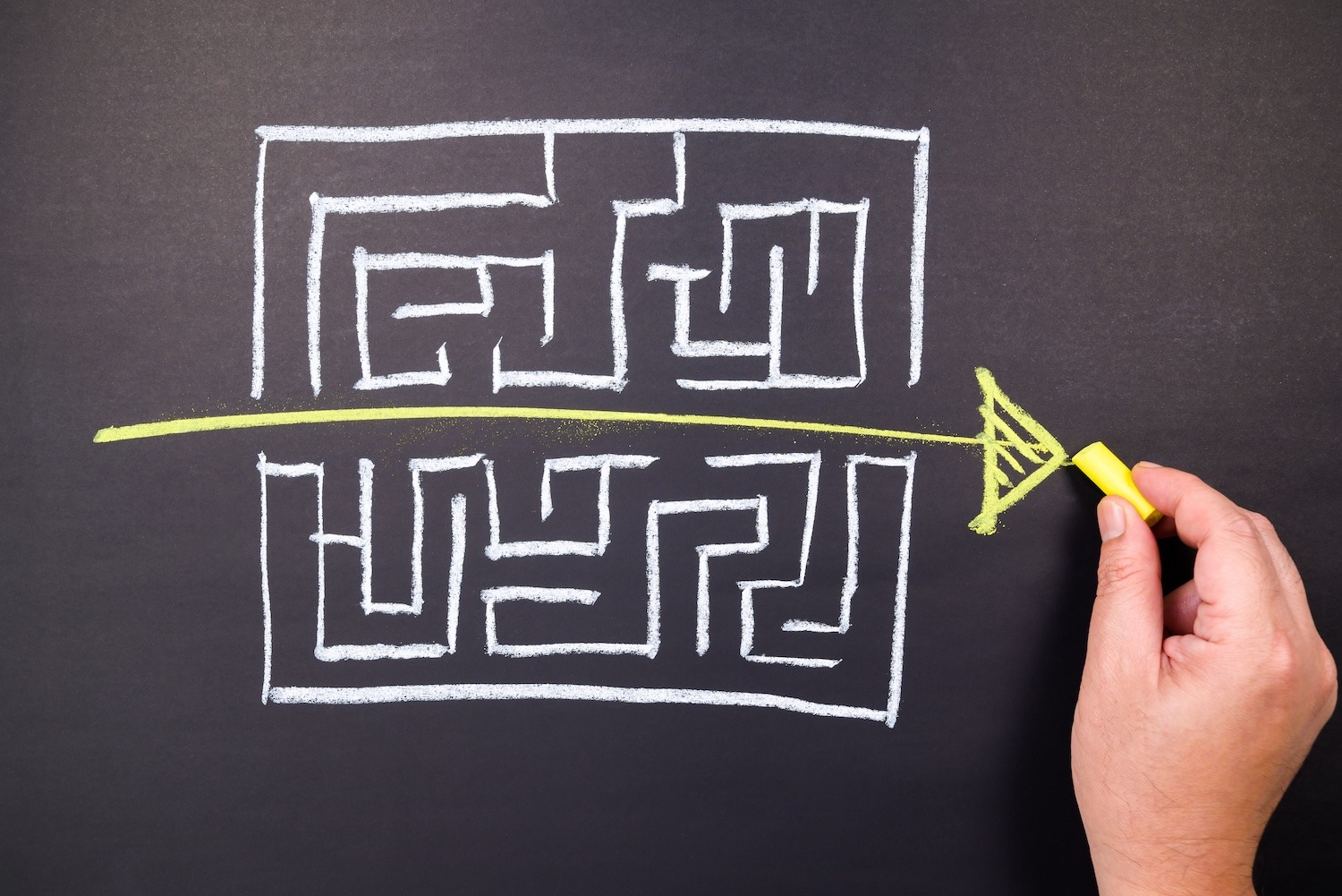 Two maze drawings on a chalkboard with a straight arrow showing a clear path through them
