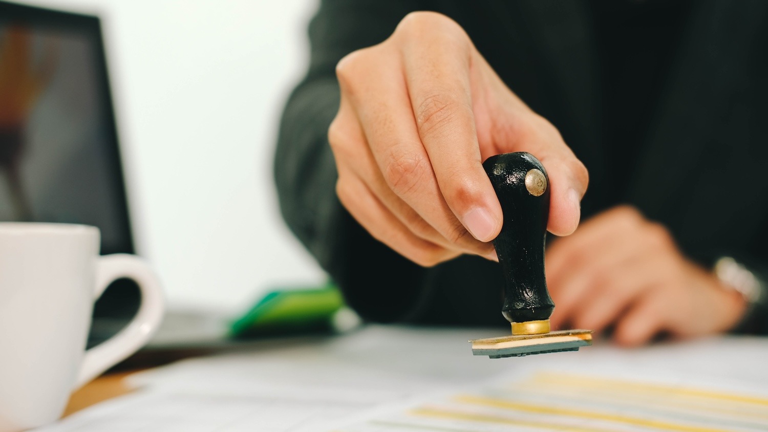 Professional applying a stamp to an official document.