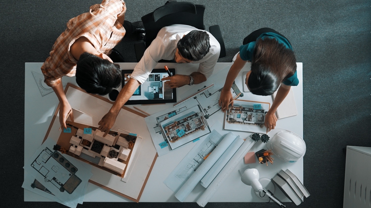 Four people reviewing property plans and documents together at a table.